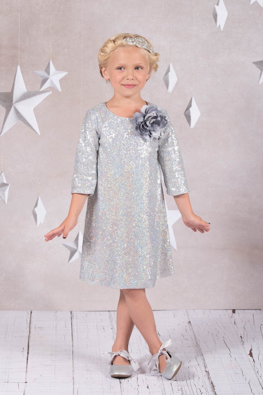 Emma's Magical Dream, sequin sleeve dress with hidden back zipper, removable flower on left shoulder, knee length with 3/4 sleeves, silver color