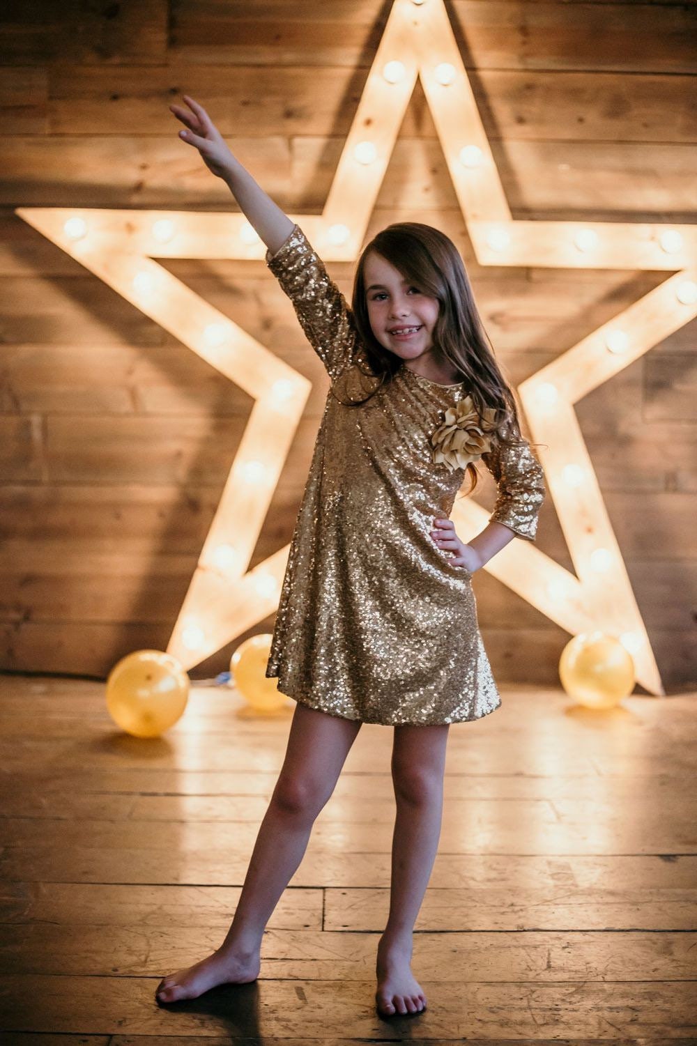 Emma's Magical Dream, sequin sleeve dress with hidden back zipper, removable flower on left shoulder, knee length with 3/4 sleeves, gold color