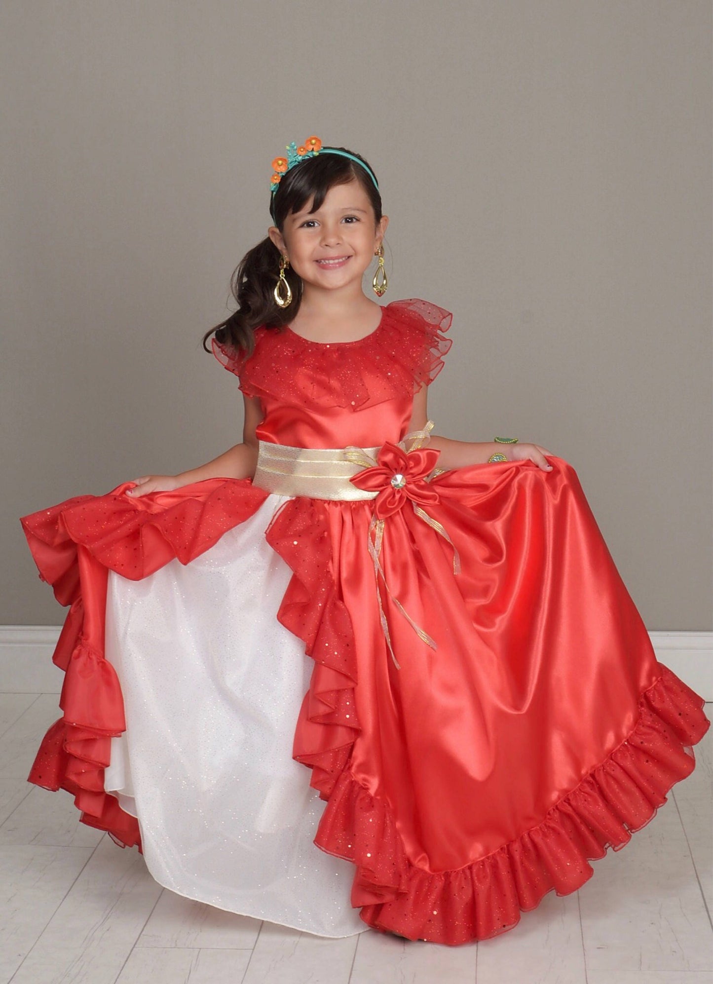 Emma's Magical Dream, Red princess ballgown with a gold tie around the waist and a red flower. It has a white underlay with the jewelry being gold dangle earrings.