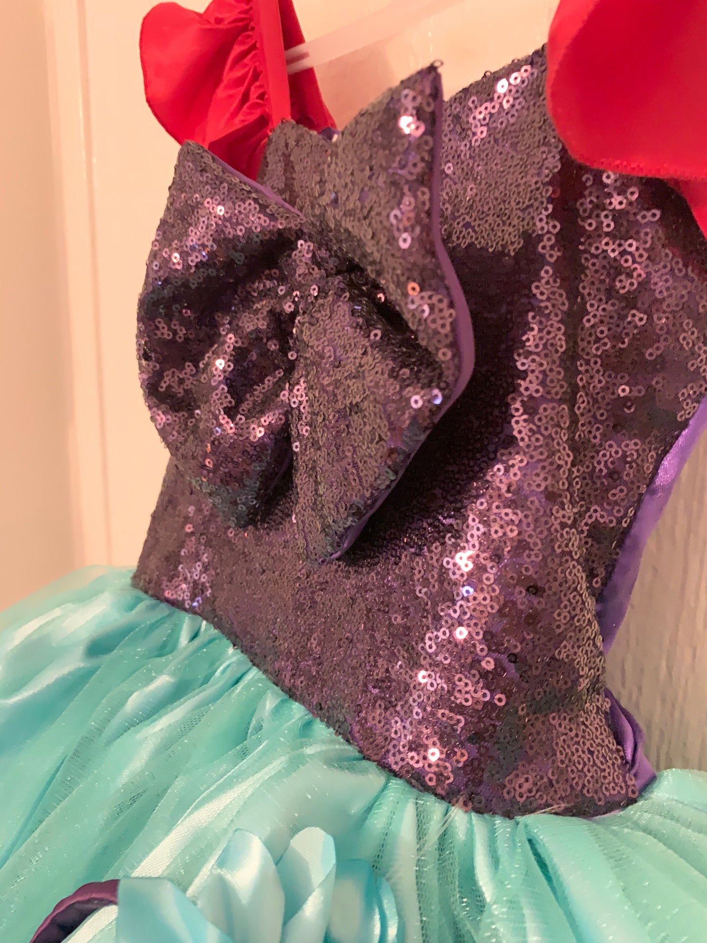 Emma's Magical Dream, Merimaid Tutu Dress, sequin top with teal tulle tutu bottom, with red ruffle sleeves, close up of purple sequin top with back bow