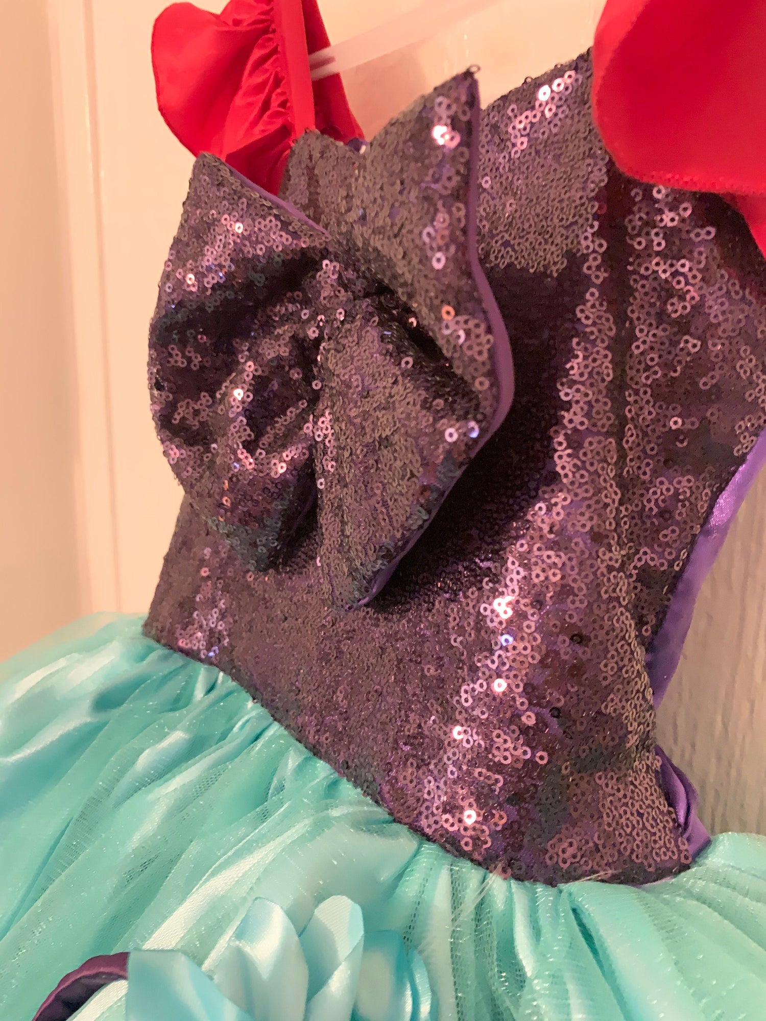 Emma's Magical Dream, Merimaid Tutu Dress, sequin top with teal tulle tutu bottom, with red ruffle sleeves, close up of purple sequin top with back bow