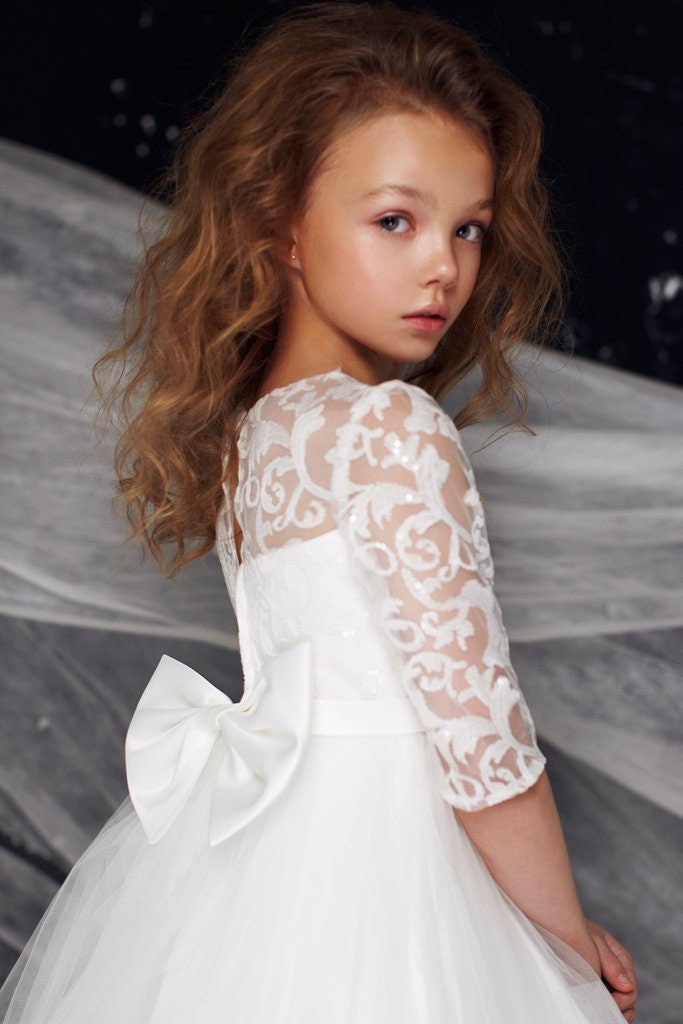 Emma's Magical Dream tulle dress up close look with white tulle and lace overlay with elbow length sleeves and big white bow on the back