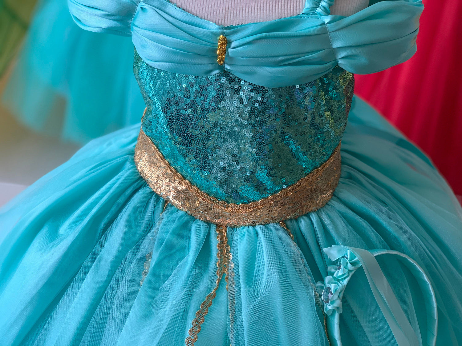 Emma's Magical Dream, Teal sequins with gold accents around the waist, features teal tulle to give the dress fullness, comes with a teal headband with a flower detail.